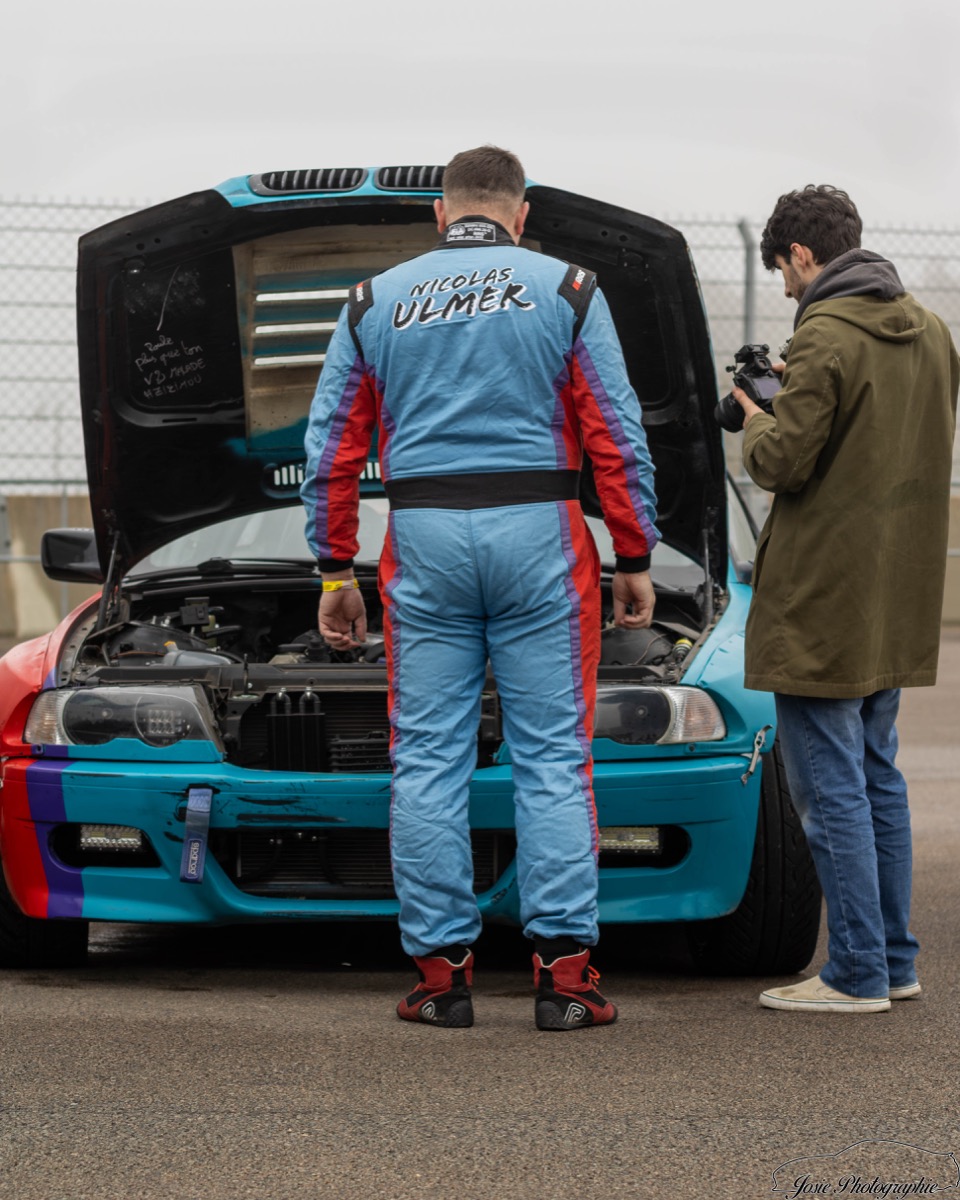 Nicolas Ulmer en combinaison devant sa BMW dans le paddock